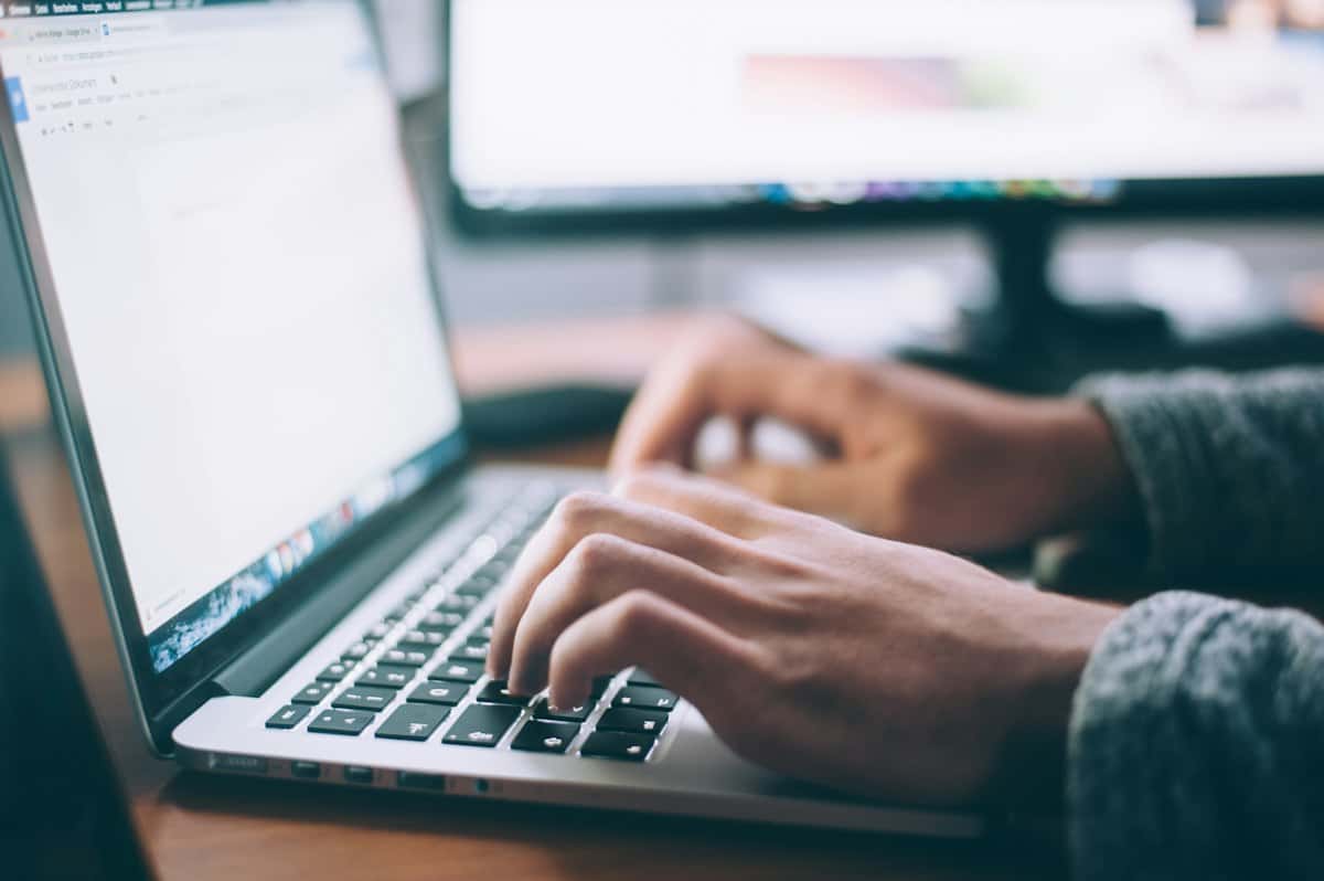 Handen die typen op een laptop